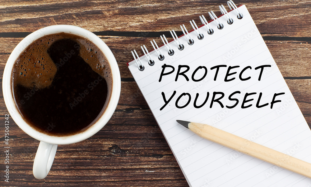 Poster protect yourself text on notebook with coffee on the wooden background