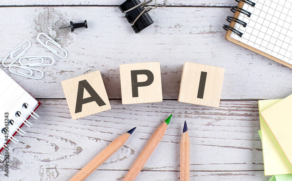 Poster api text on wooden block with office tools on the wooden background