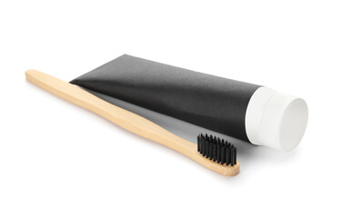 Tube with black tooth paste and brush on white background
