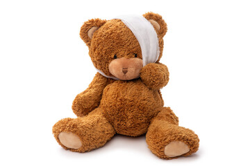 medicine, healthcare and childhood concept - teddy bear toy with bandaged head having toothache on...