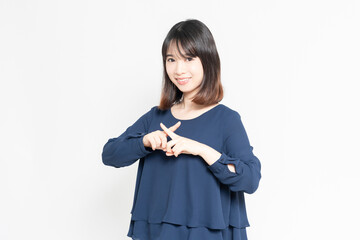 白い背景の前に立ってNGのポーズをする若い女性