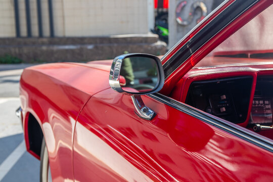 The vehicle's wing mirror of a red classic car or Muscle car