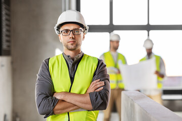 architecture, construction business and building concept - male architect in helmet and safety west...