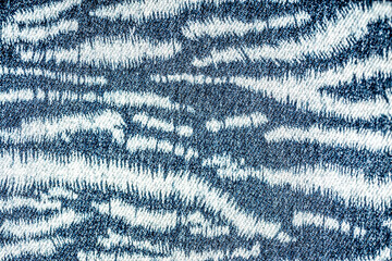 Jeans background. Denim fabric closeup. Textures of clothing fabric with fashion embroidery blue...