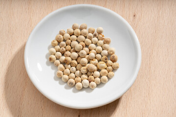 Detailed and large close up shot of peppercorns on a small plate