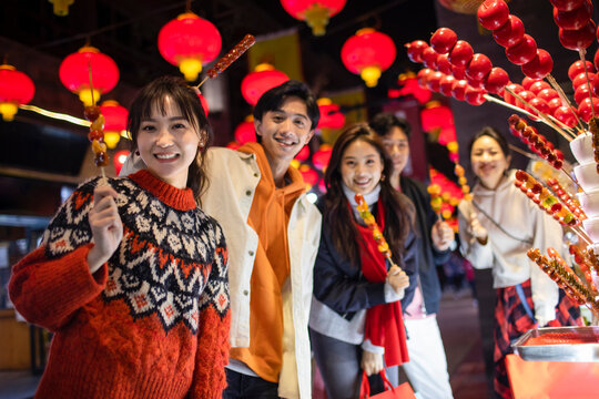 Young friends with candied haw celebrating Chinese New Year