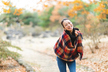 紅葉の公園で遊ぶ女性