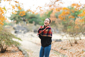 紅葉の公園で遊ぶ女性