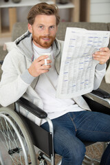man in wheelchair reading newspaper at care home