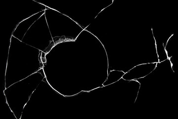 Cracked broken glass, hole in a broken window texture on a black background.