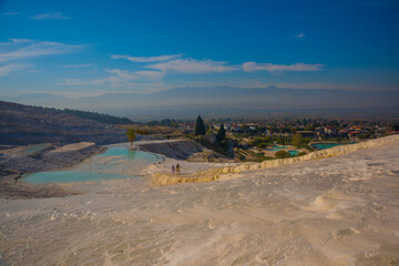 PAMUKKALE, TURKEY: White travertines and a pool with clear water in Pamukkale on a sunny day.