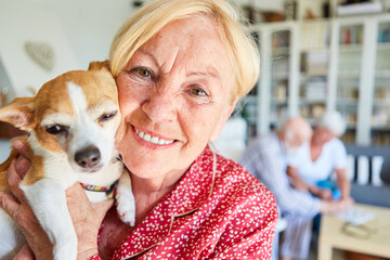 Happy elderly woman with a dog in her arms