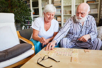 Seniors play dominoes together in the retirement home
