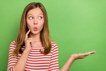 Photo of young astonished girl demonstrate promo sale look empty space wonder isolated over green...