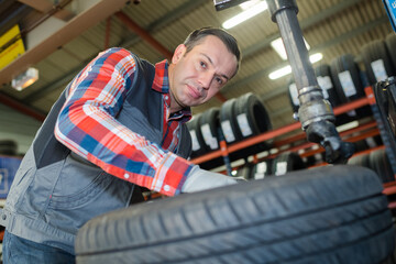 man checking tyres in a garage