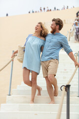 happy couple walking holding hands at the beach