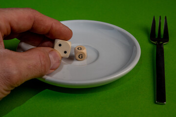 Concept Image for 2G control, white cubes form 2G on a withe plate against a green background, male...