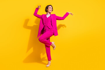 Fototapeta na wymiar Photo of charming funny young lady wear pink suit dancing smiling isolated yellow color background