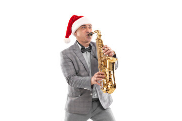Elegant adult man wears in Santa's hat plays on saxophone on white background. New Year party 