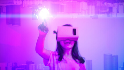 Fototapeta na wymiar Metaverse digital cyber world technology, Little girl with virtual reality VR goggle playing AR augmented reality game and entertainment,