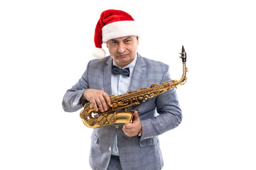 Sceptical musician man wears in Santa's hat holds saxophone over studio background