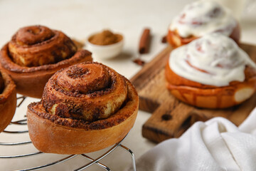 Grid with tasty cinnamon rolls on light background, closeup