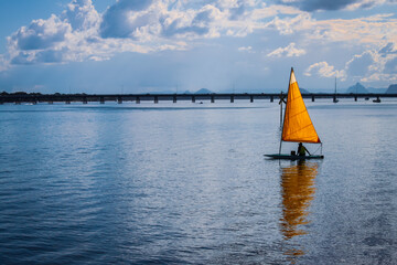 One man sailboat - single yellow sail on turquoise water - matching sky - Pumicestone Channel...