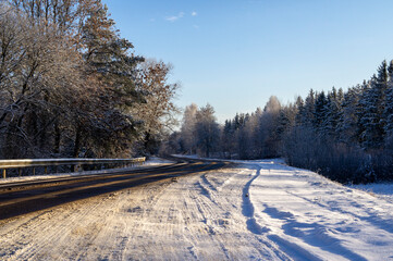 Beautiful empty winter snow road on a sunny cold day