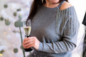 Woman celebrating New Year with glass of champagne in her hand.