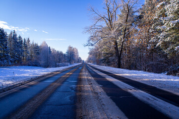 Beautiful empty winter snow road on a sunny cold day