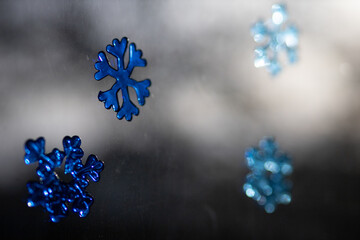 Closeup of snowflake stickers on a window with a blurry background