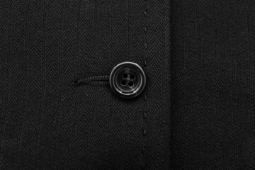 Button on black cloth, closeup