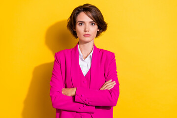 Portrait of attractive serious businesswoman economist wearing vest folded arms isolated over bright yellow color background