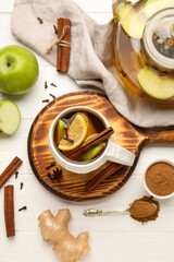 Cup of tasty fruit tea with cinnamon on white wooden background