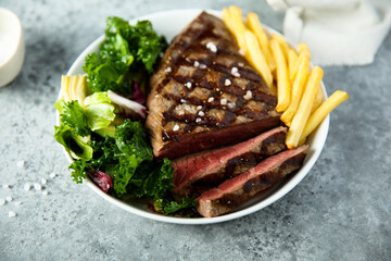 Beef steak with French fries and salad