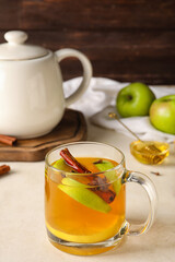 Glass cup of tasty fruit tea with cinnamon on white background