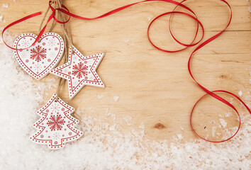 Wooden christmas decorations and tinsel on a light wooden background