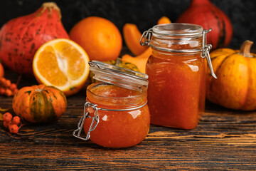 Jars of sweet pumpkin jam on table