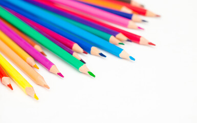 School stationery items. Creation Multicolored pencils on a blank white sheet. On a white background. Children's drawing, artist.