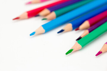 School stationery items. Creation Multicolored pencils on a blank white sheet. On a white background. Children's drawing, artist.