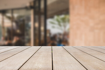 Wooden board empty table top and blurred background in coffee shop and restaurant with old red bricks in vintage and loft style, Mock up for display of product.