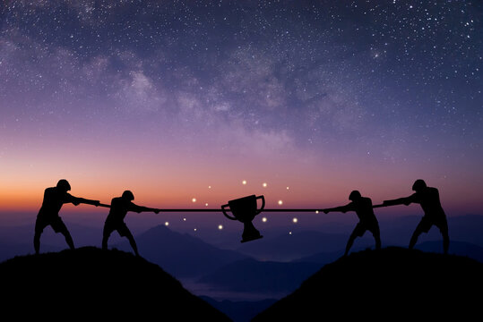 Silhouette Of Four Young Businessman Pulling Tug Of War With A Rope On Top Of The Mountain With Night Sky And Star Background. Concept For Business Competition, Rivalry, Challenge Or Dispute.