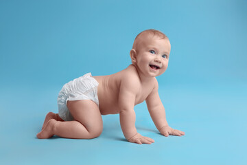 Cute baby in dry soft diaper crawling on light blue background - obrazy, fototapety, plakaty