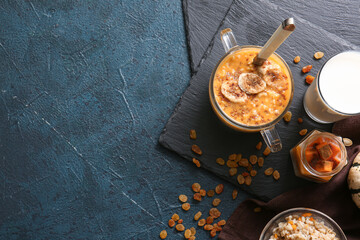 Pot of tasty oatmeal with pumpkin on black background