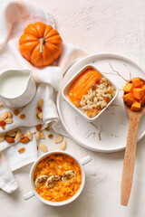 Pot and bowl of tasty oatmeal with pumpkin on white background