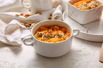 Pot of tasty oatmeal with pumpkin and banana on white background