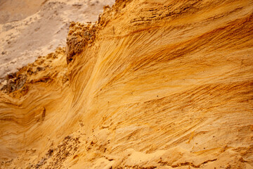 Textural sand, with  relief surface, multi-colored layers and different in size of granules, in outdoor sand career, after mining ore and sand for construction.