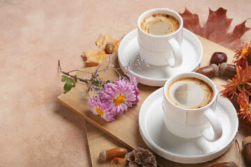 Cups of coffee, flowers and natural forest decor on color background