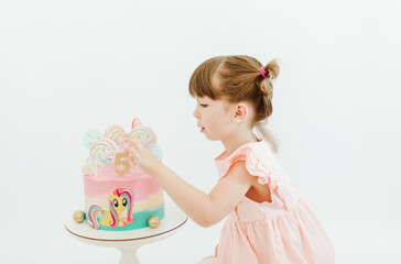 Pretty little girl celebrate her five years old Birthday. Cute child is wearing pink dress on the white background