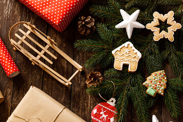 Christmas, New Year decoration cookies and biscuits on wooden background with conifer evergreen branches